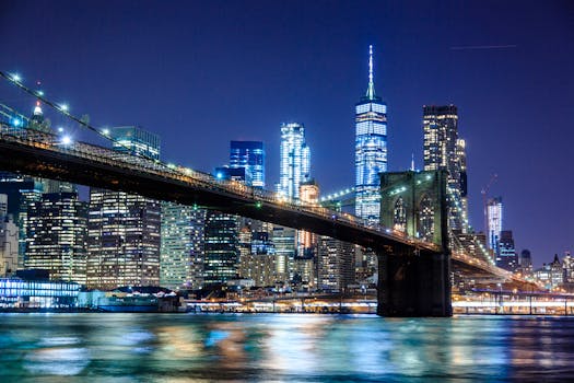 Stunning view of the Brooklyn Bridge and New York City skyline illuminated at night.