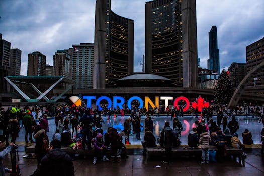 Vibrant evening at Toronto City Hall with festive crowd enjoying the cityscape.